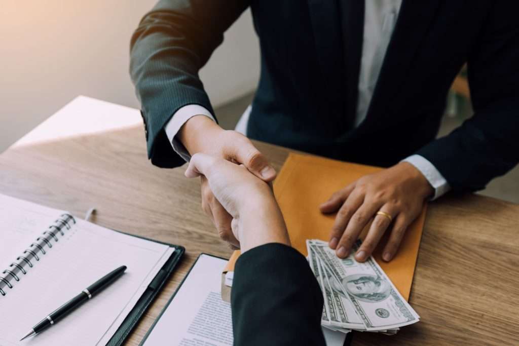 two people shaking hands and conspiring